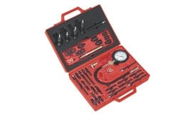 Engine compression tester kit with gauge and various attachments for automotive diagnostics, presented in a red carrying case.