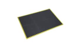 Interlocking rubber floor mat featuring a textured black surface and a bright yellow border, suitable for various indoor uses.