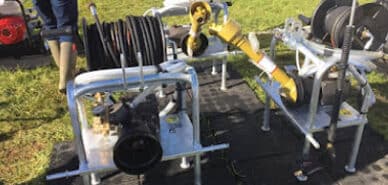 Industrial hose reel equipment with hoses and fittings on display, showcasing durable construction and functionality for various applications.